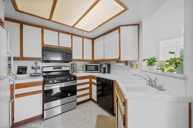 kitchen featuring sink, white cabinets, and black appliances