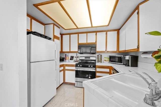 kitchen featuring appliances with stainless steel finishes, sink, and white cabinetry