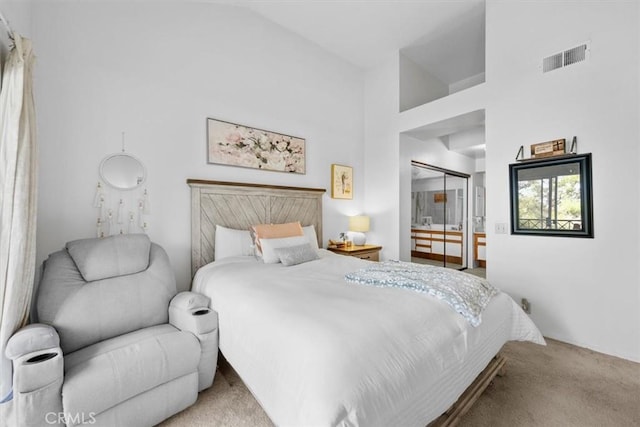 bedroom with a closet, light colored carpet, and high vaulted ceiling