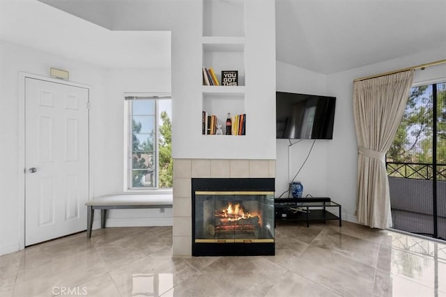 living room featuring built in shelves and a fireplace