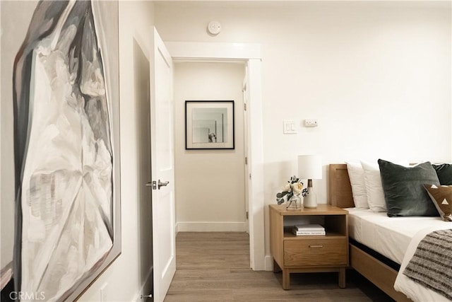 bedroom with baseboards and wood finished floors