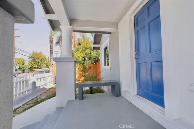 property entrance featuring stucco siding and fence