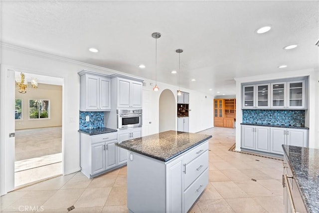 17931 Calle, Los Arboles, Rowland Heights, CA 91748 - kitchen featuring ornamental molding, light tile patterned floors, a center island, stainless steel oven, and arched walkways