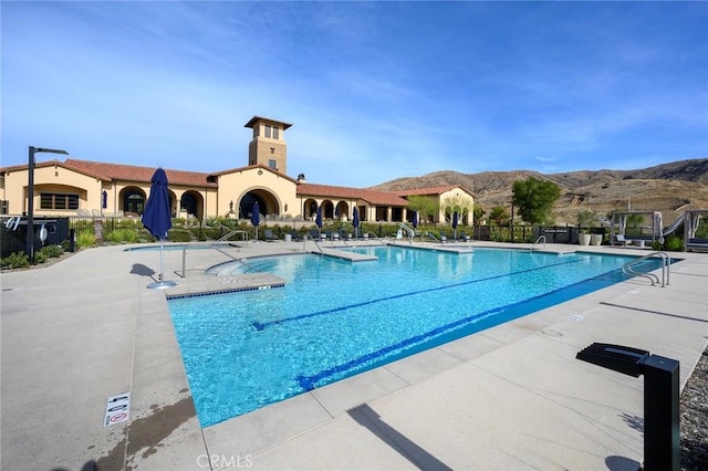 view of swimming pool featuring a mountain view and a patio