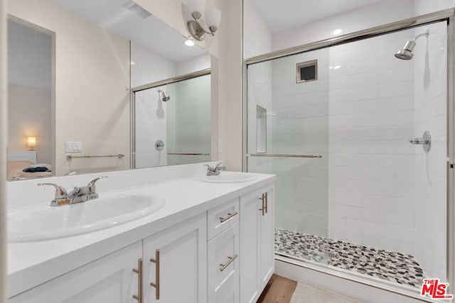 bathroom with vanity, wood-type flooring, and an enclosed shower