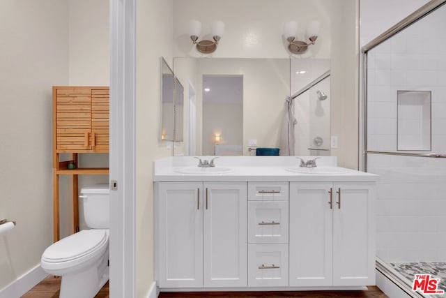 bathroom featuring vanity, toilet, and a shower with shower door