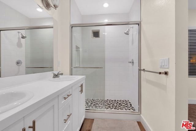 bathroom featuring vanity, an enclosed shower, and wood-type flooring