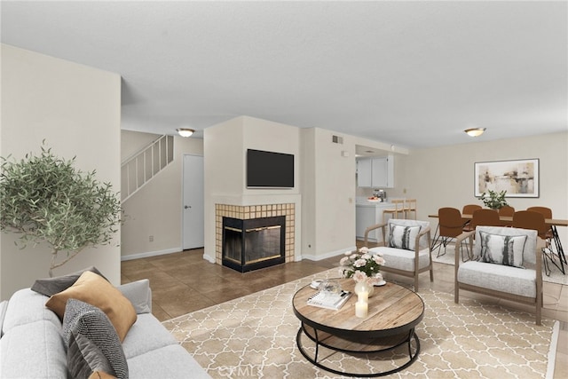 living room with a tile fireplace and tile patterned flooring