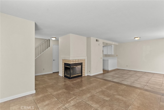 unfurnished living room featuring a tile fireplace