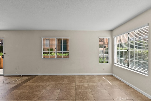 spare room with tile patterned floors and a textured ceiling