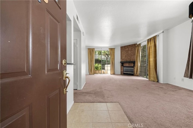 unfurnished living room with a large fireplace and light colored carpet