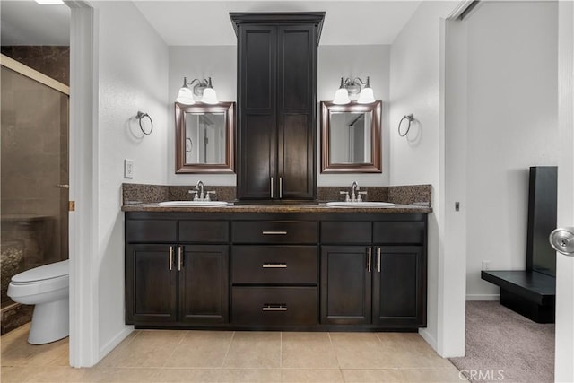 bathroom featuring toilet, vanity, tile patterned floors, and walk in shower