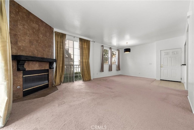 unfurnished living room with light colored carpet and a tiled fireplace