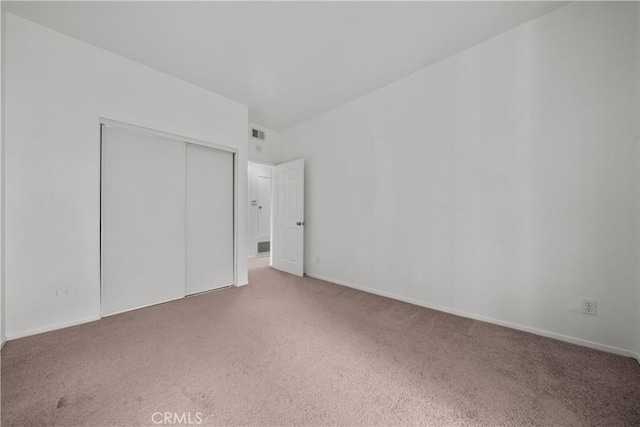 unfurnished bedroom featuring carpet floors and a closet