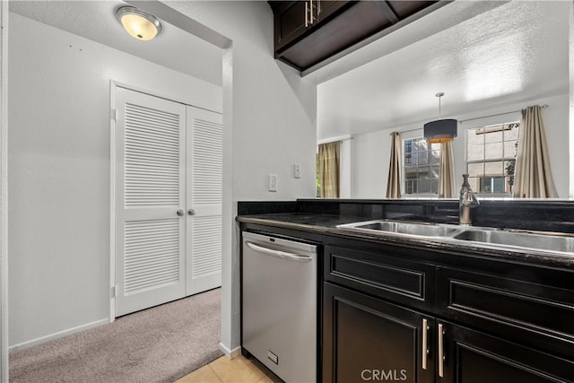 kitchen featuring dishwasher, sink, hanging light fixtures, a textured ceiling, and light carpet