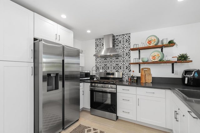 kitchen featuring white cabinetry, appliances with stainless steel finishes, sink, and wall chimney exhaust hood