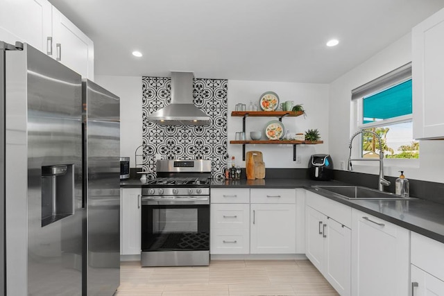 kitchen featuring white cabinets, appliances with stainless steel finishes, sink, and wall chimney range hood