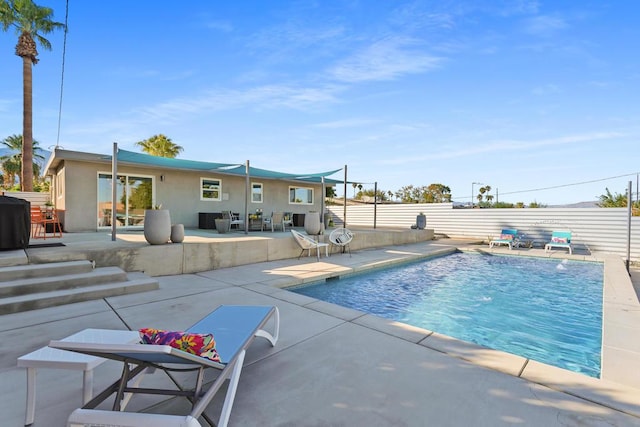 view of pool with grilling area and a patio area