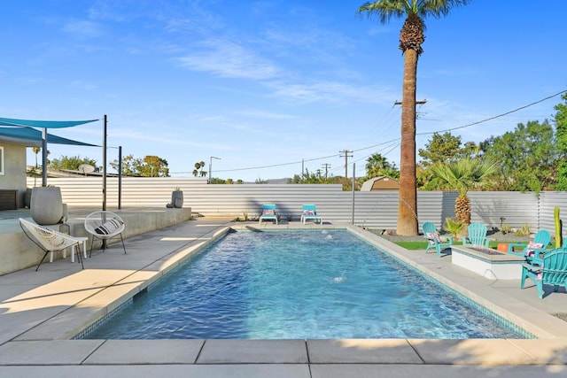 view of pool featuring a patio area and a fire pit