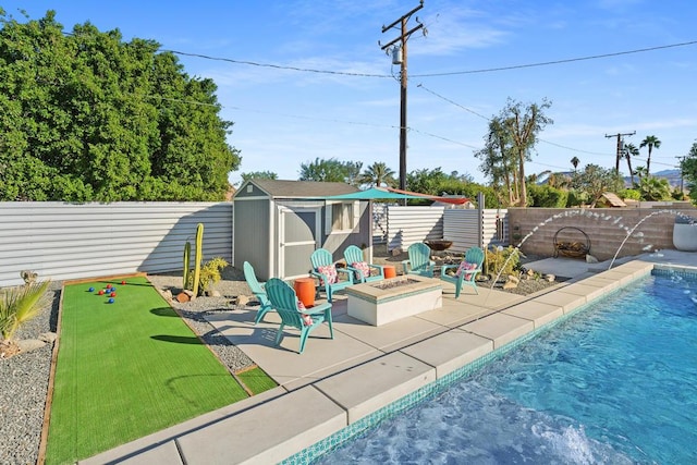 view of swimming pool featuring a shed, a patio, pool water feature, and an outdoor fire pit