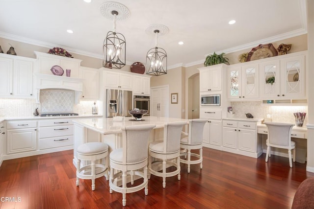 kitchen featuring appliances with stainless steel finishes, tasteful backsplash, a kitchen island, pendant lighting, and white cabinets