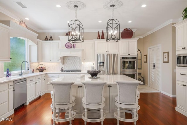 kitchen featuring hanging light fixtures, appliances with stainless steel finishes, sink, and a kitchen island