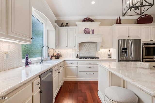 kitchen with light stone countertops, decorative light fixtures, stainless steel appliances, sink, and backsplash