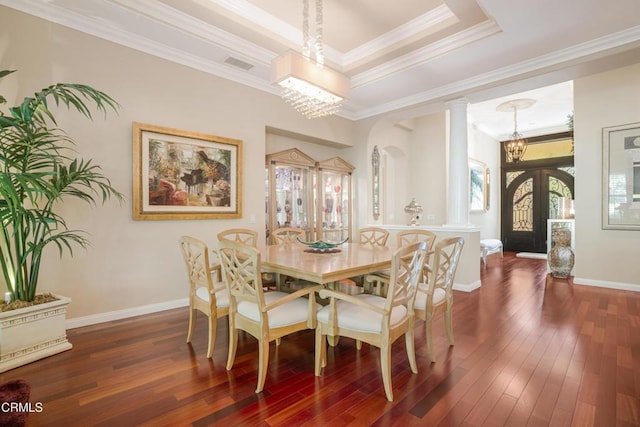 dining space with dark hardwood / wood-style floors, ornamental molding, french doors, and a notable chandelier