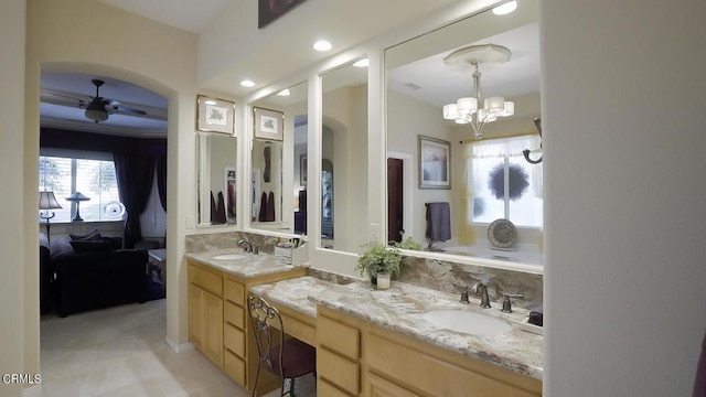 bathroom with ceiling fan with notable chandelier, plenty of natural light, and vanity