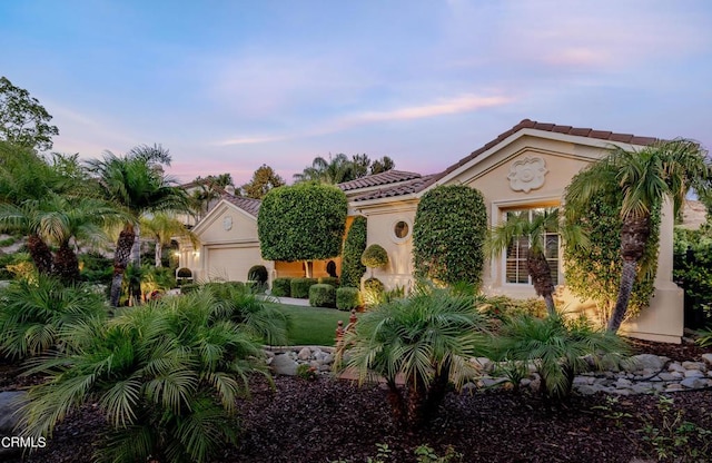 mediterranean / spanish-style home with a garage