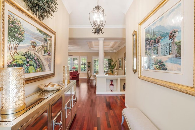 hall with dark hardwood / wood-style flooring, crown molding, a notable chandelier, and decorative columns