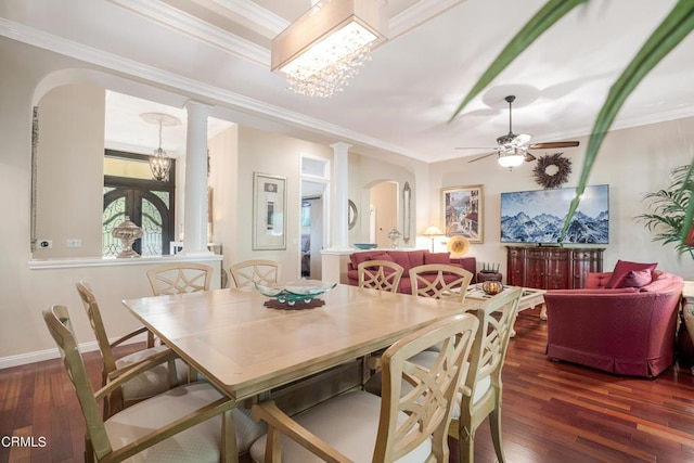 dining area with dark hardwood / wood-style floors, ornamental molding, french doors, ceiling fan with notable chandelier, and decorative columns