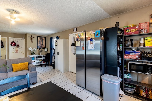 kitchen with a textured ceiling, appliances with stainless steel finishes, and light tile patterned floors