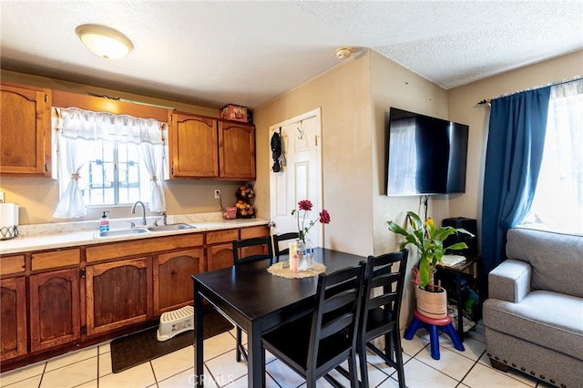 kitchen with sink, a textured ceiling, and light tile patterned floors