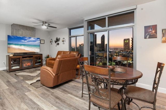 living room featuring ceiling fan, floor to ceiling windows, and hardwood / wood-style flooring