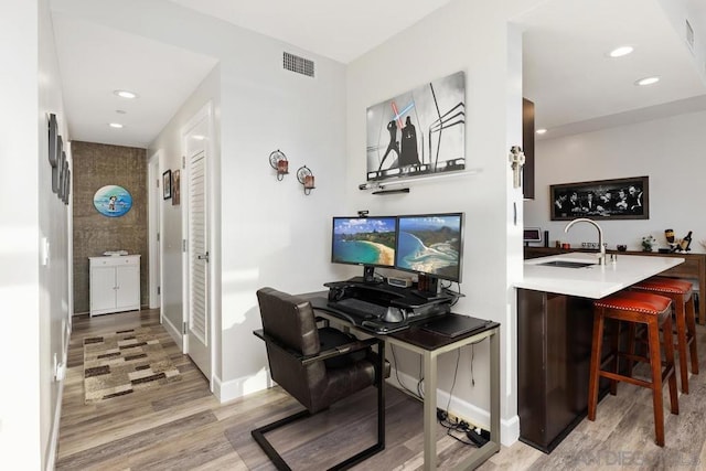 home office featuring sink and light hardwood / wood-style floors