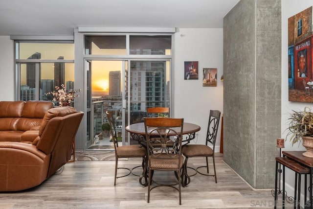 dining area with hardwood / wood-style floors and expansive windows