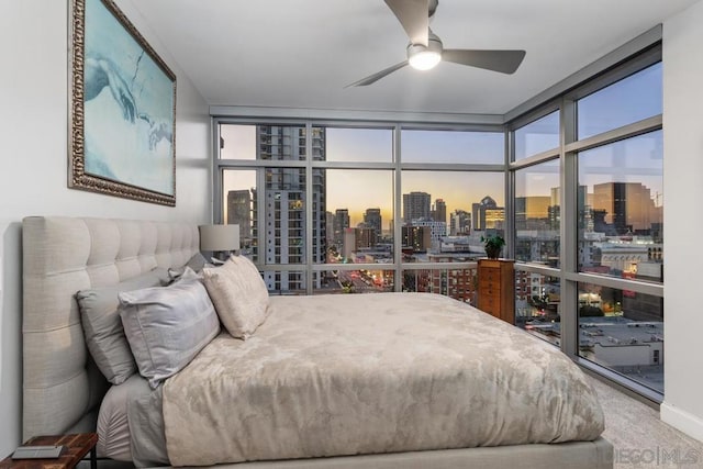 carpeted bedroom featuring ceiling fan and a wall of windows