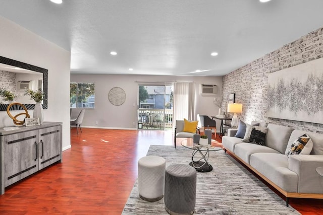 living room with a wall mounted air conditioner, dark hardwood / wood-style floors, and brick wall