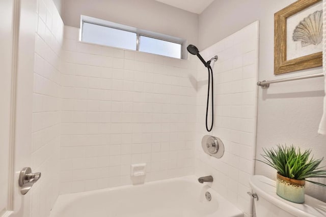 bathroom with toilet and tiled shower / bath combo