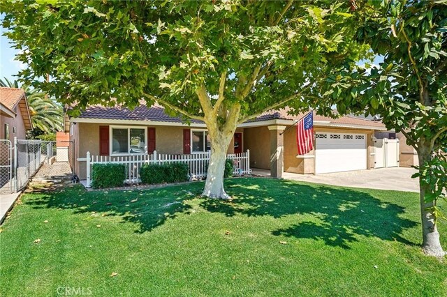 ranch-style house featuring a front lawn, covered porch, and a garage