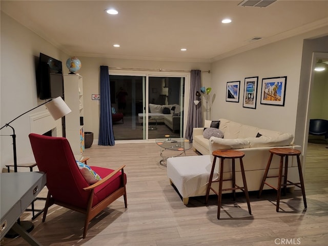 living room with crown molding and light wood-type flooring