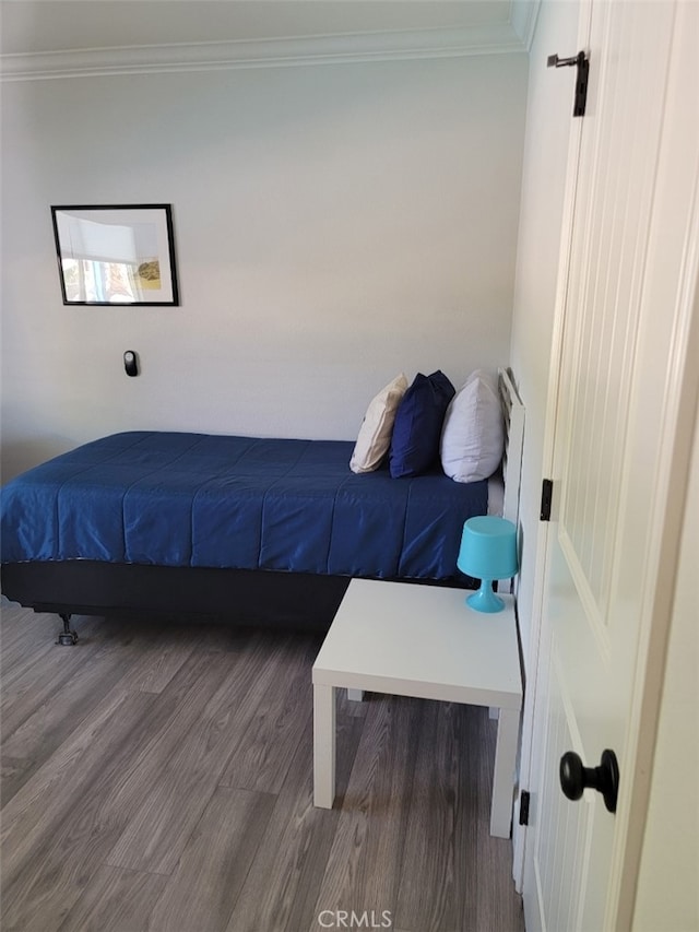 bedroom featuring crown molding and hardwood / wood-style floors