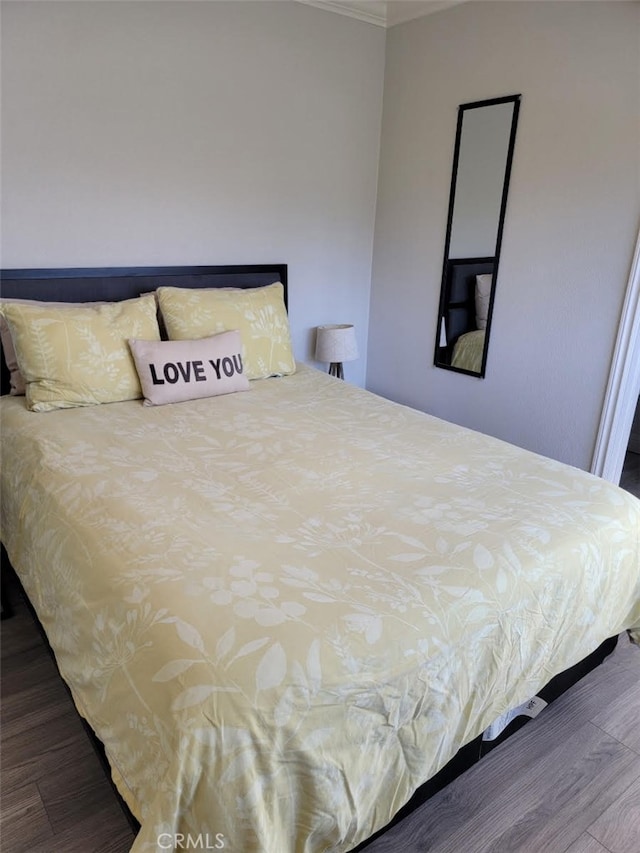 bedroom with crown molding and hardwood / wood-style floors