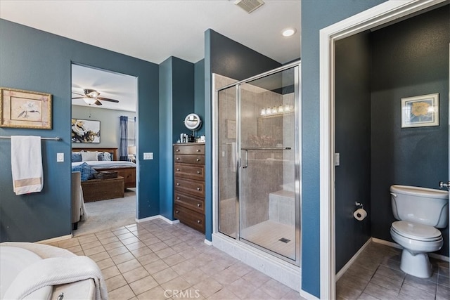 bathroom featuring toilet, tile patterned flooring, a shower with shower door, and ceiling fan