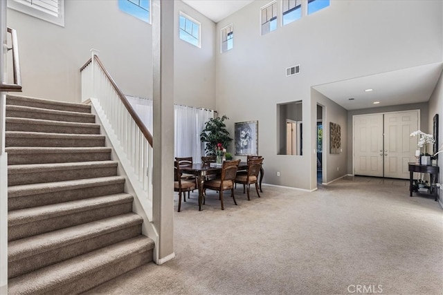 carpeted foyer featuring a high ceiling