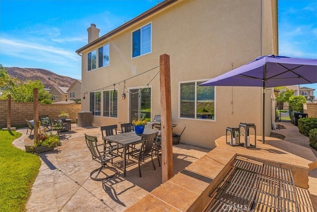 rear view of house featuring a mountain view and a patio area