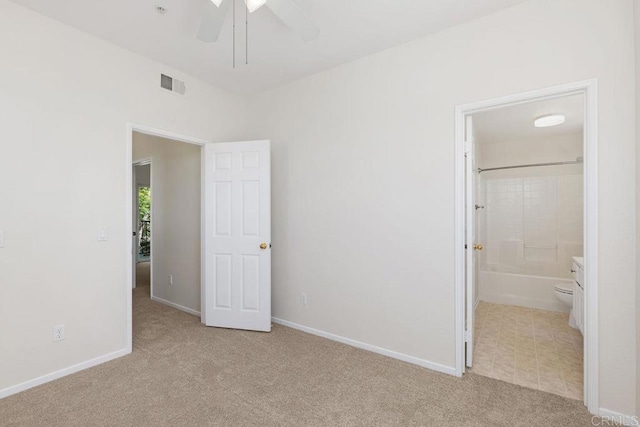 unfurnished bedroom featuring ceiling fan, ensuite bathroom, and light carpet