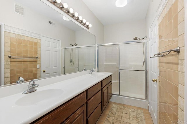 bathroom featuring a shower with shower door, vanity, and tile patterned flooring