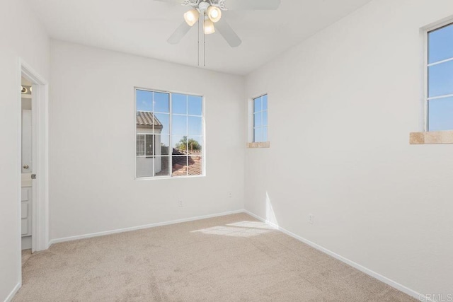 carpeted spare room featuring ceiling fan